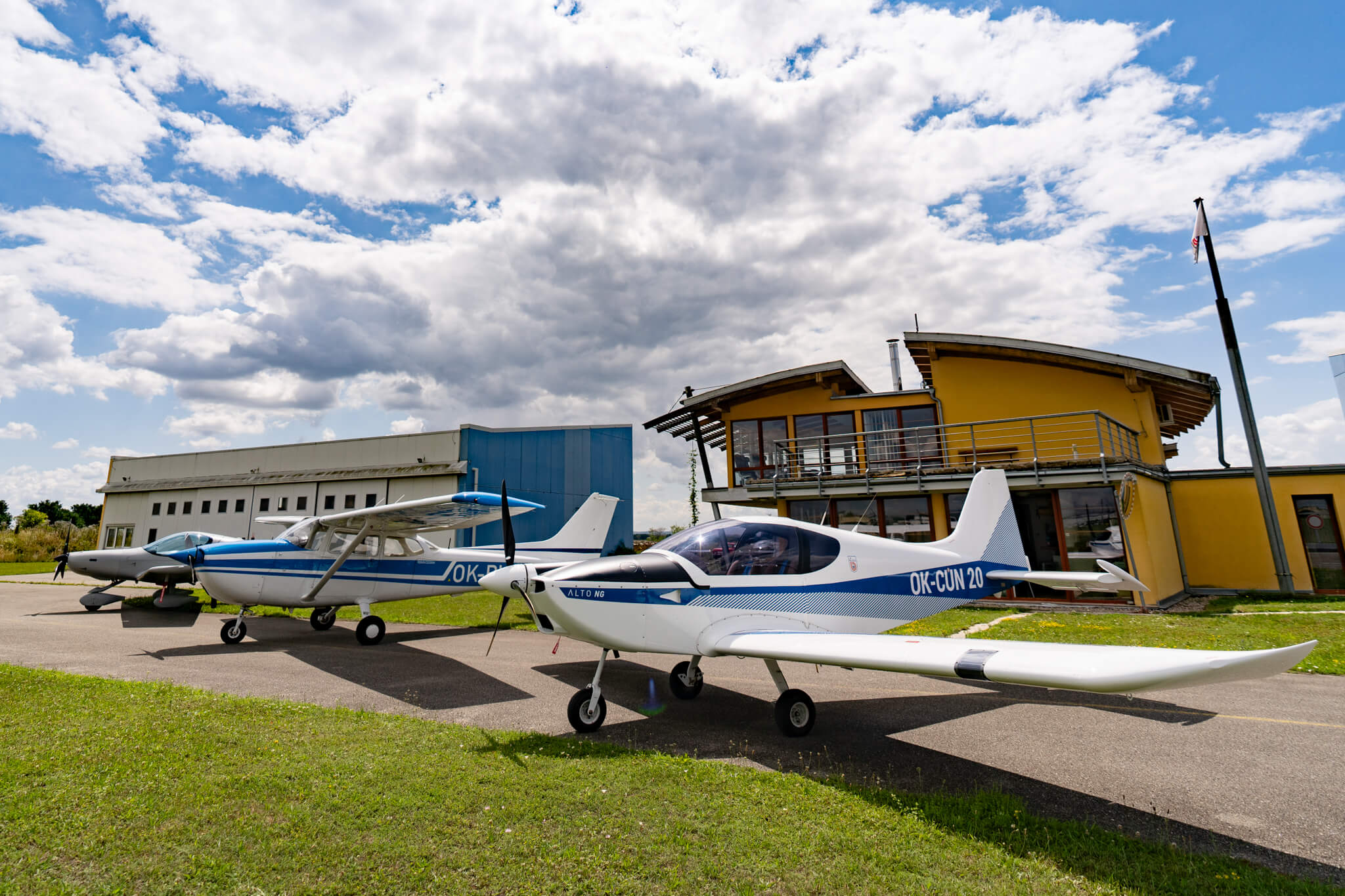 Aeroklubová budova s hangárem a před tím 3 letadla