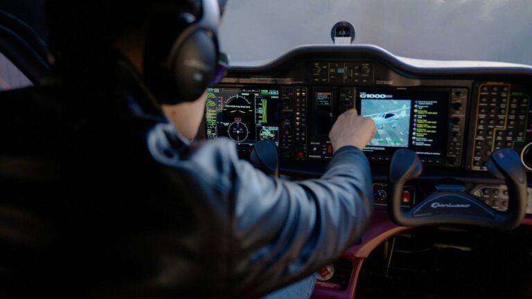 Pohled přes rameno pilota na digitální avioniku Garmin G1000 v moderním letadle.